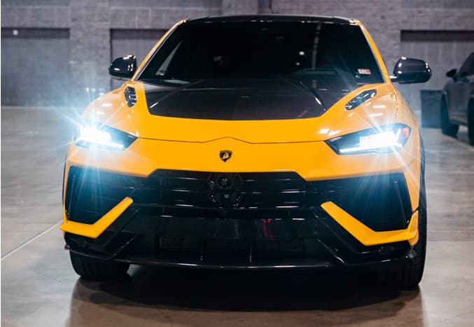Lamborghini Urus Performante exterior image, front view with lights on.